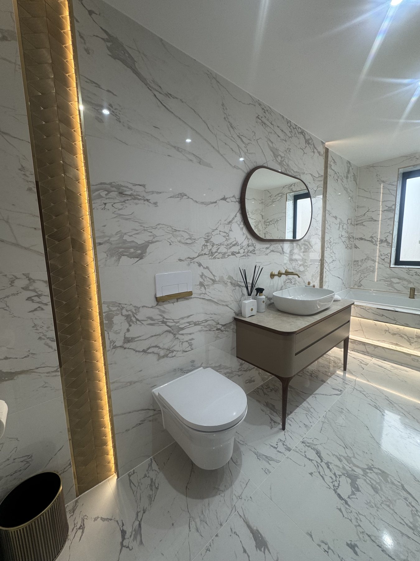 Finished marble-effect bathroom with warm feature lighting